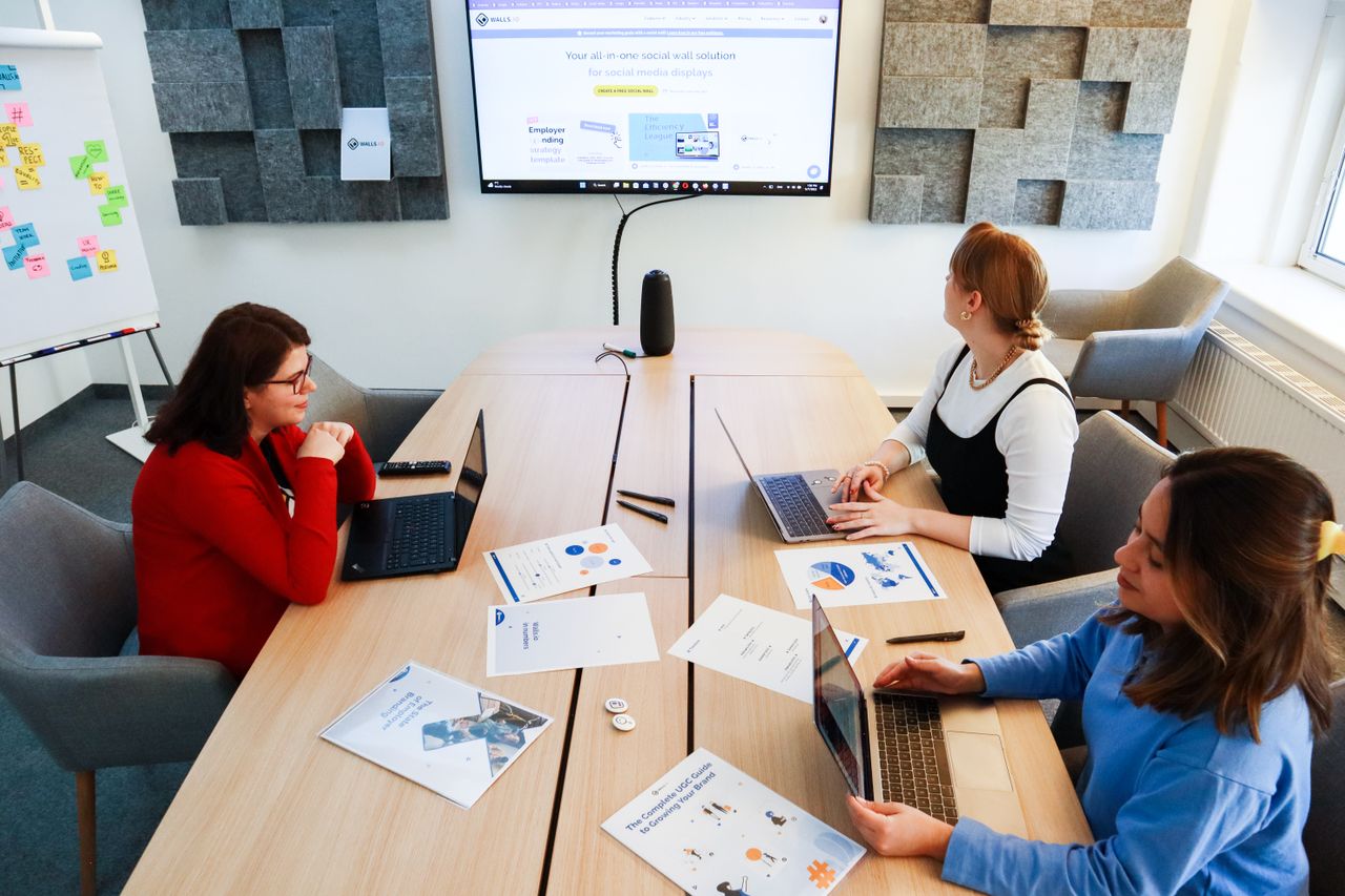 The Art of Drawing Readers In: Your attractive post title goes here Three women collaborating in a modern office with laptops and presentation materials.